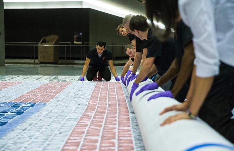 Installation team rolling up flag. Photo by Jin Lee, 9/11 Memorial.