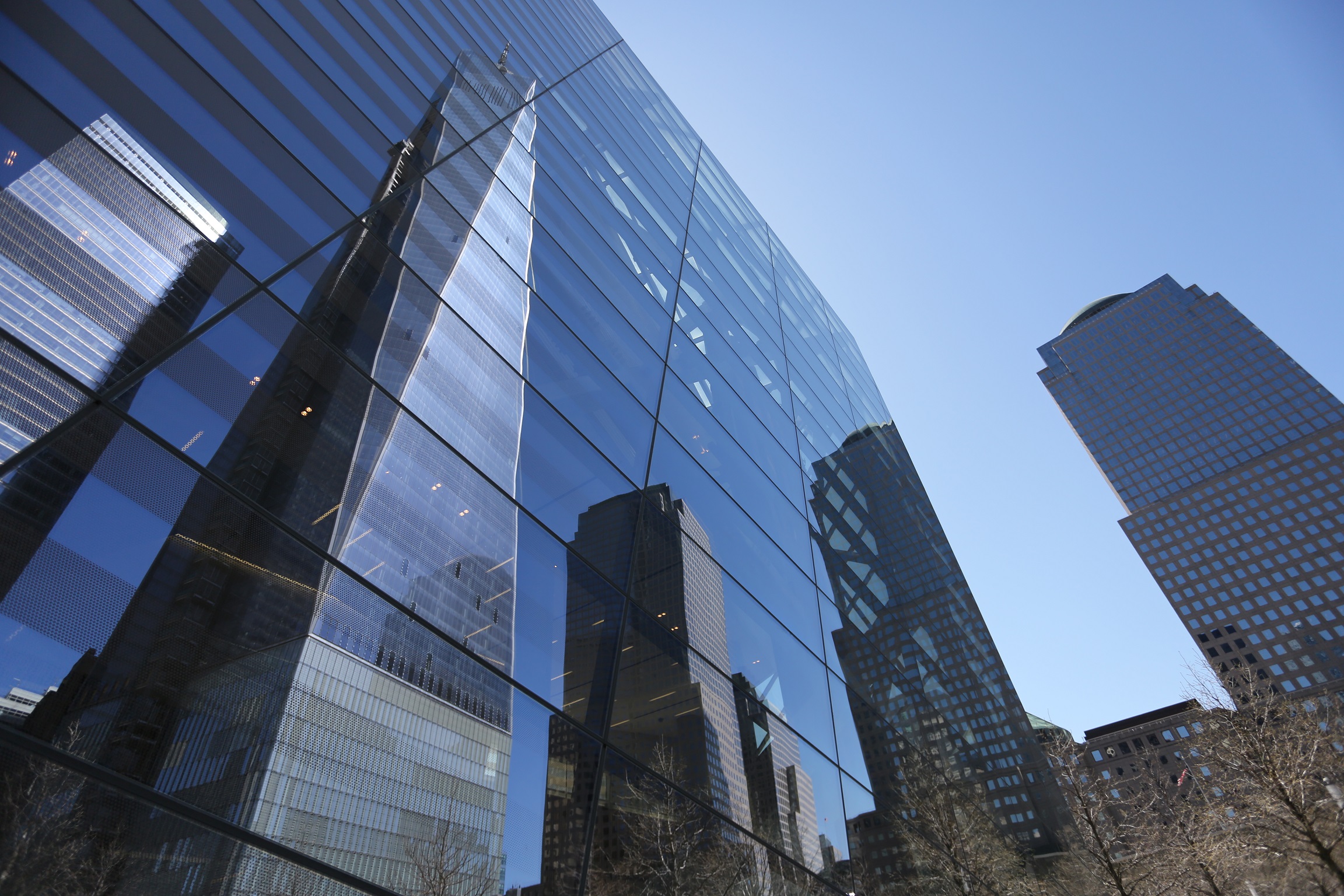 One World Trade Center reflects on the windows of the Museum pavilion at the 9/11 Memorial.