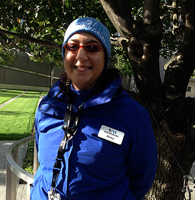 U.S. Naval Officer Rina Percoco smiles for a photo beside the Survivor Tree on a sunny day.