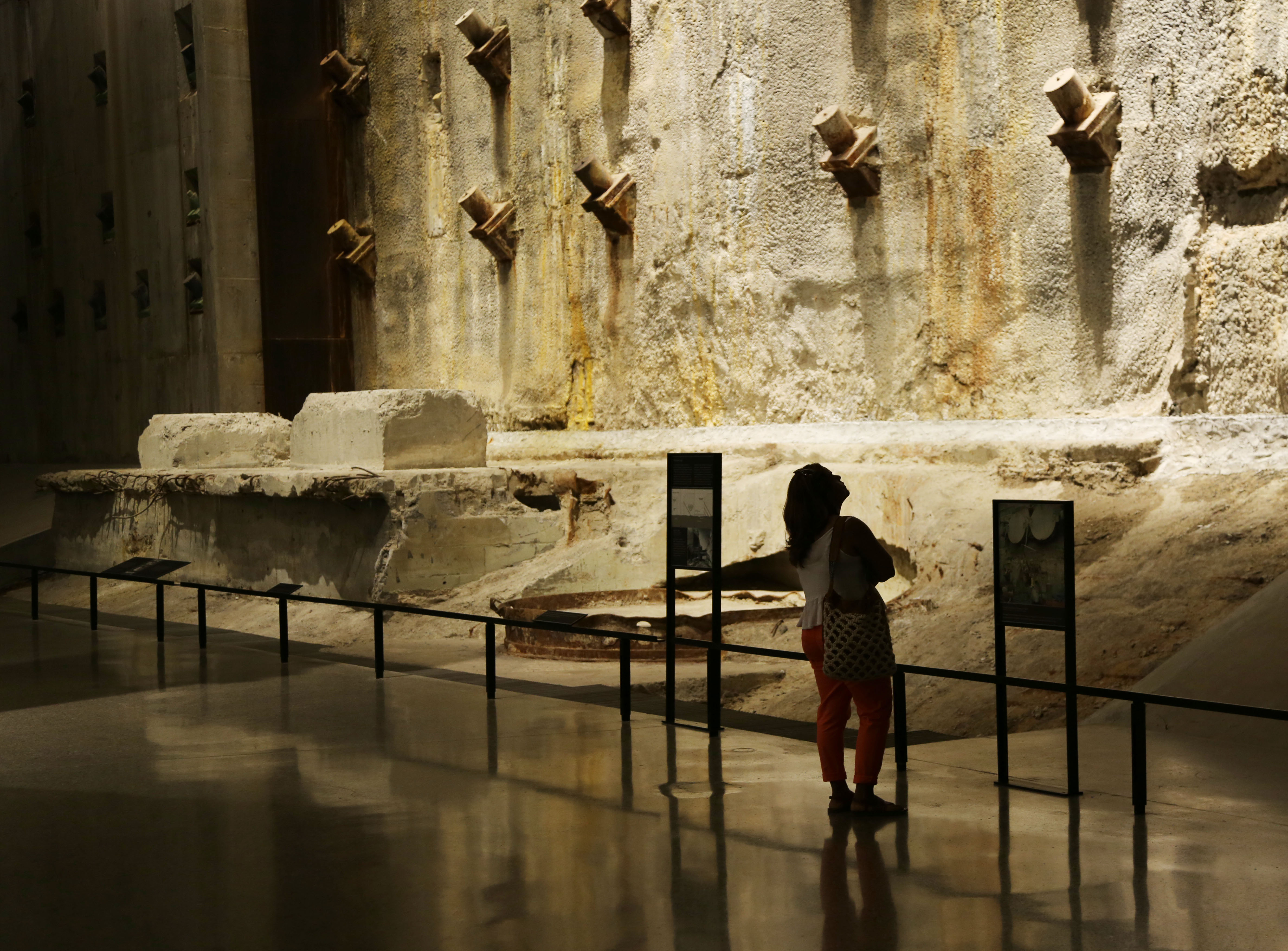 A woman looks up at an illuminated slurry wall in Foundation Hall.