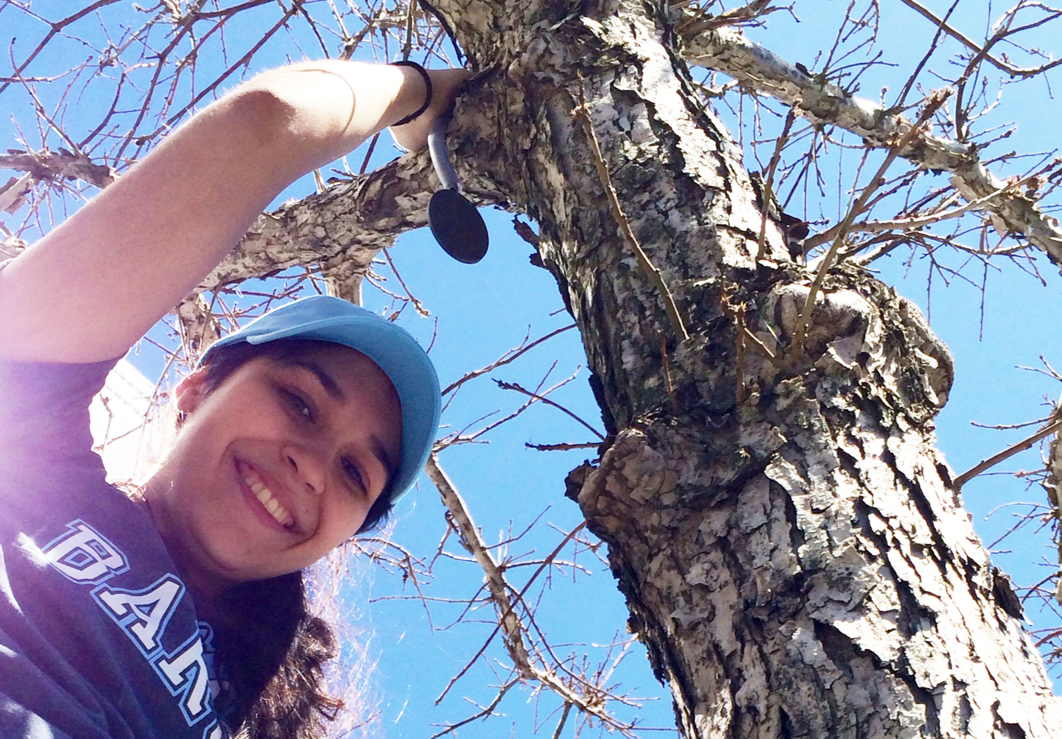 A volunteer, Isabella Arroyo, smiles for a photo as she tags a tree on the 9/11 Memorial Plaza.