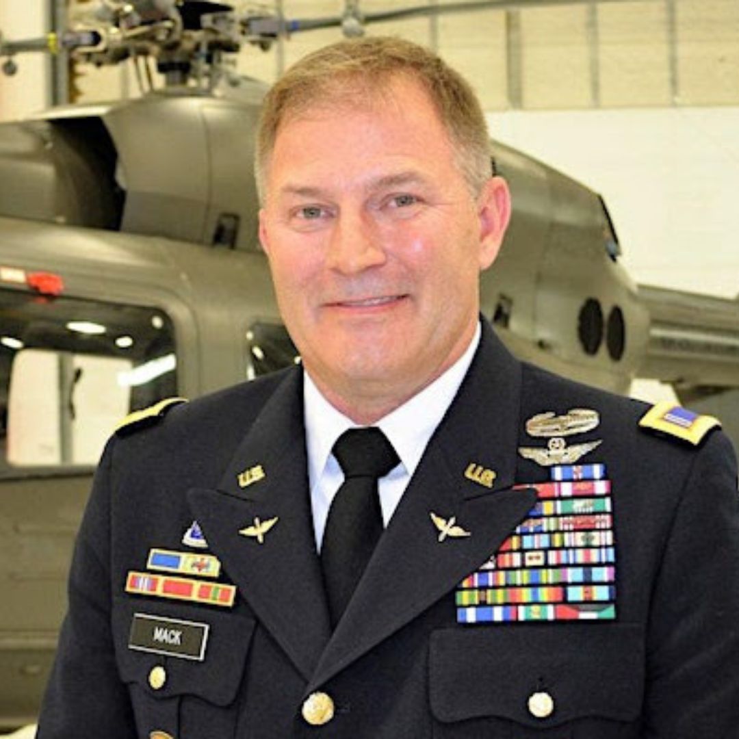 Alan Ruck in uniform, in front of an army helicopter