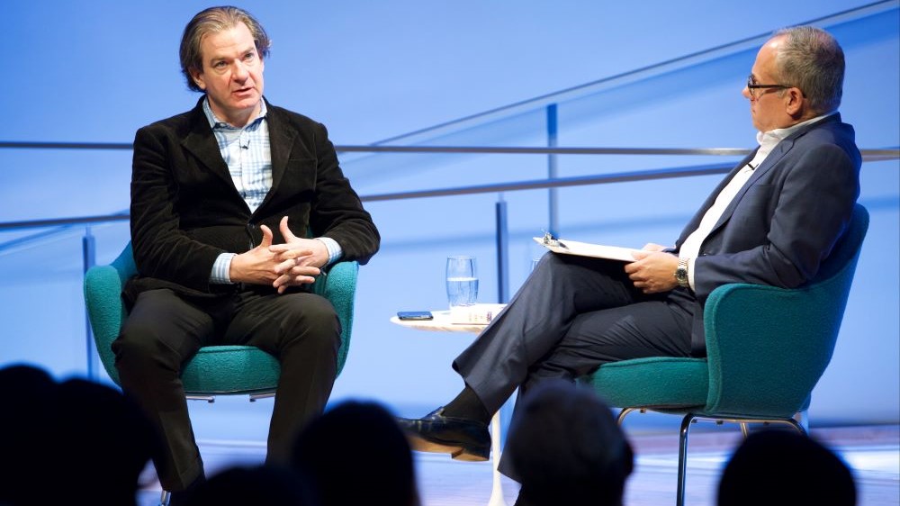 New York Times best-selling author and CNN National Security Analyst Peter Bergen sits next to Clifford Chanin, the executive vice president and deputy director for museum programs, as he speaks onstage at the Museum Auditorium. The heads of several audience members are silhouetted in the foreground.