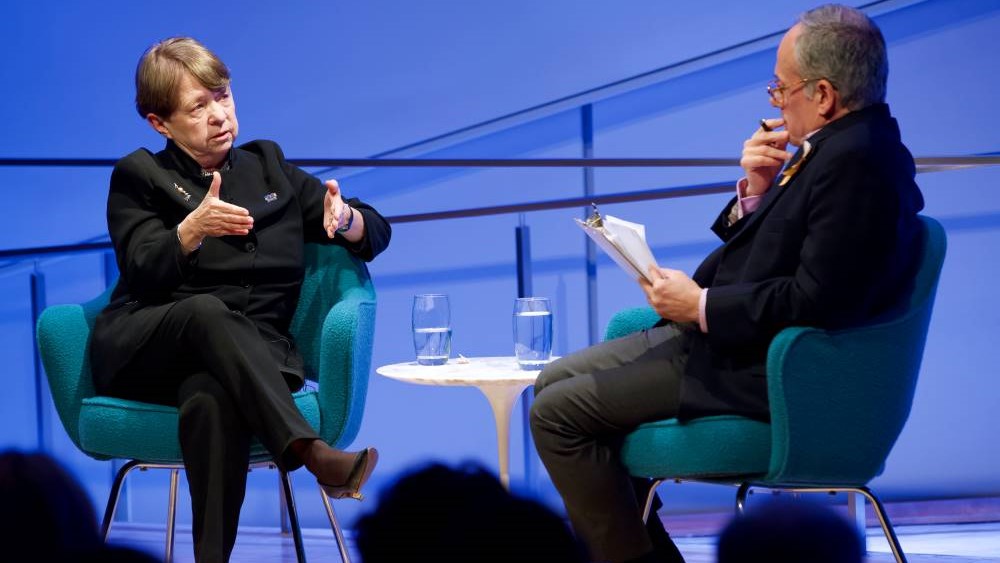 Former U.S. Attorney Mary Jo White of the Southern District of New York speaks with Clifford Chanin, the executive vice president and deputy director for museum programs, onstage at the Museum Auditorium. White gestures as she speaks to Chanin, who is holding a clipboard in one hand and a pen in the other.