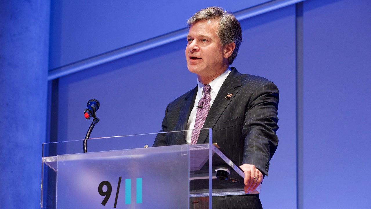 A man stands at a podium and addresses an unseen audience.