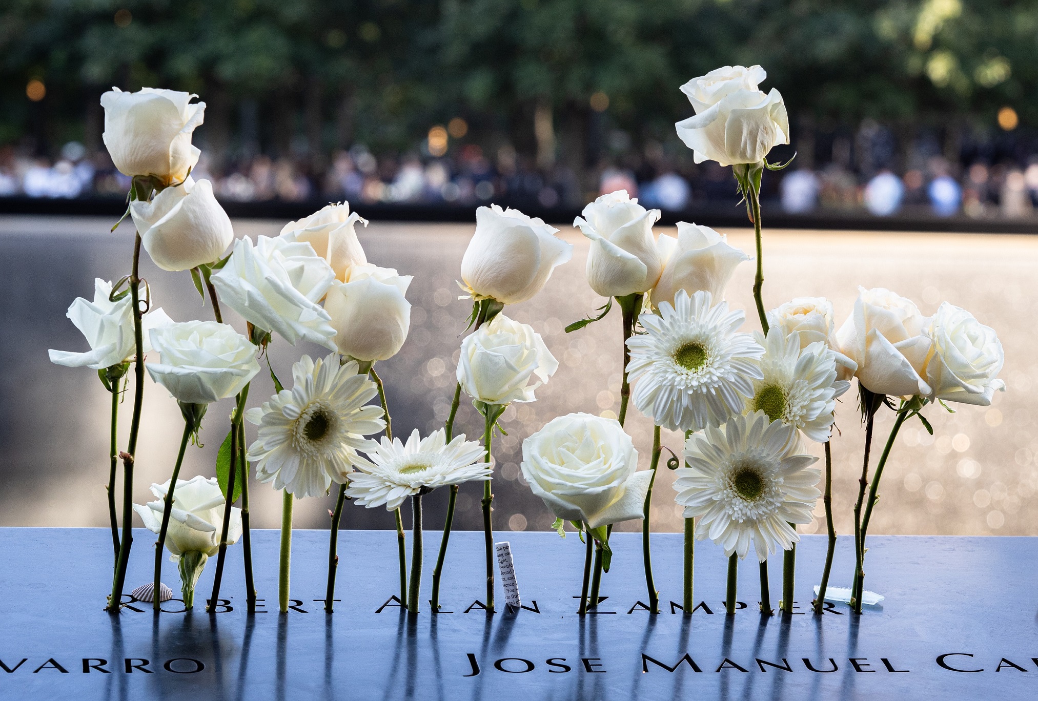 White flowers at the names of victims on the Memorial
