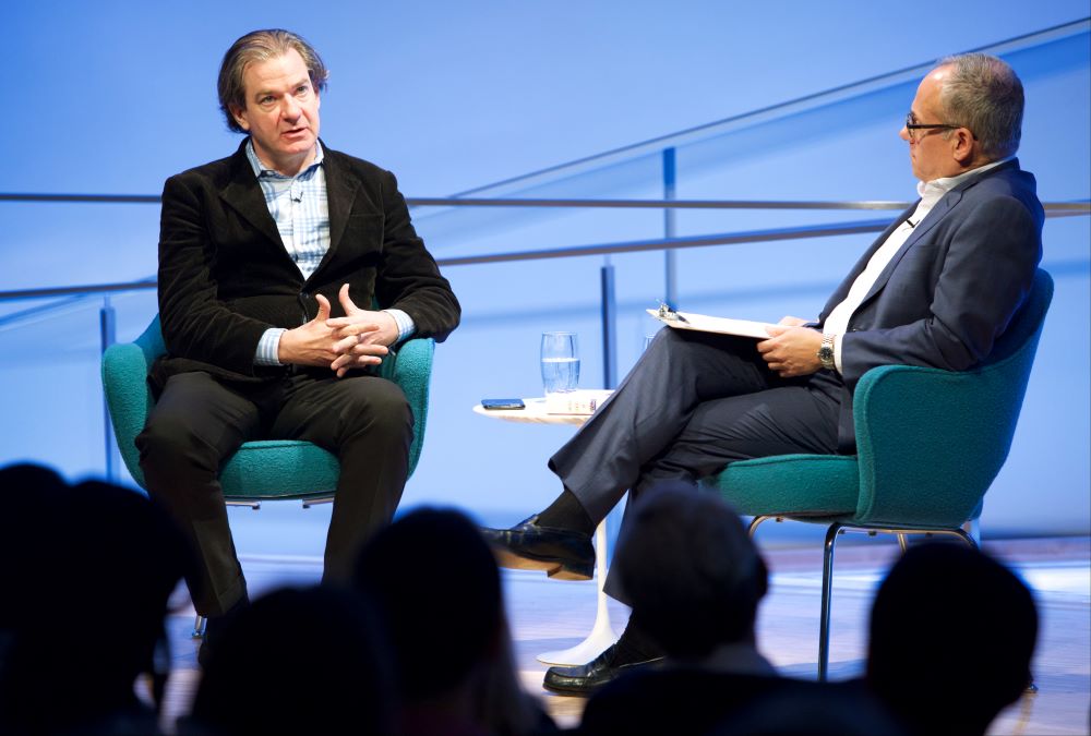 New York Times best-selling author and CNN National Security Analyst Peter Bergen sits next to Clifford Chanin, the executive vice president and deputy director for museum programs, as he speaks onstage at the Museum Auditorium. The heads of several audience members are silhouetted in the foreground.