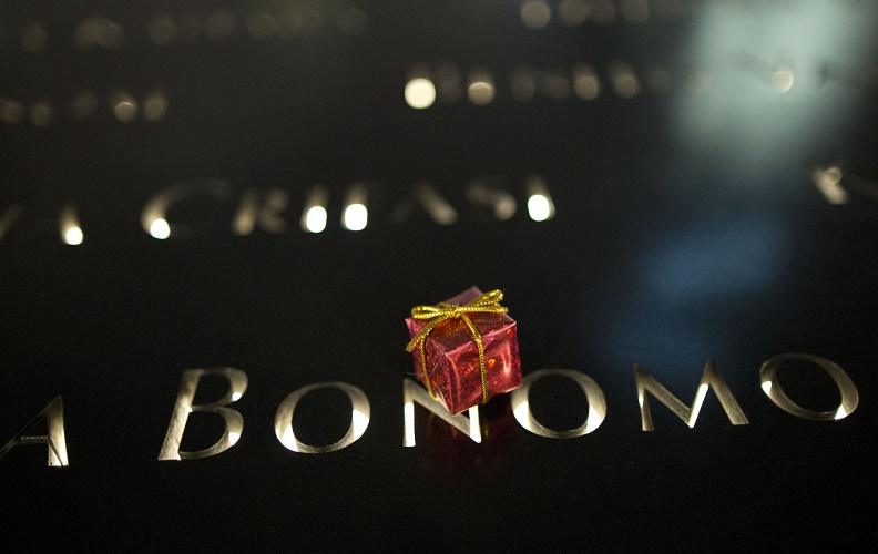 A tiny red-wrapped present left on the 9/11 Memorial parapet at night.