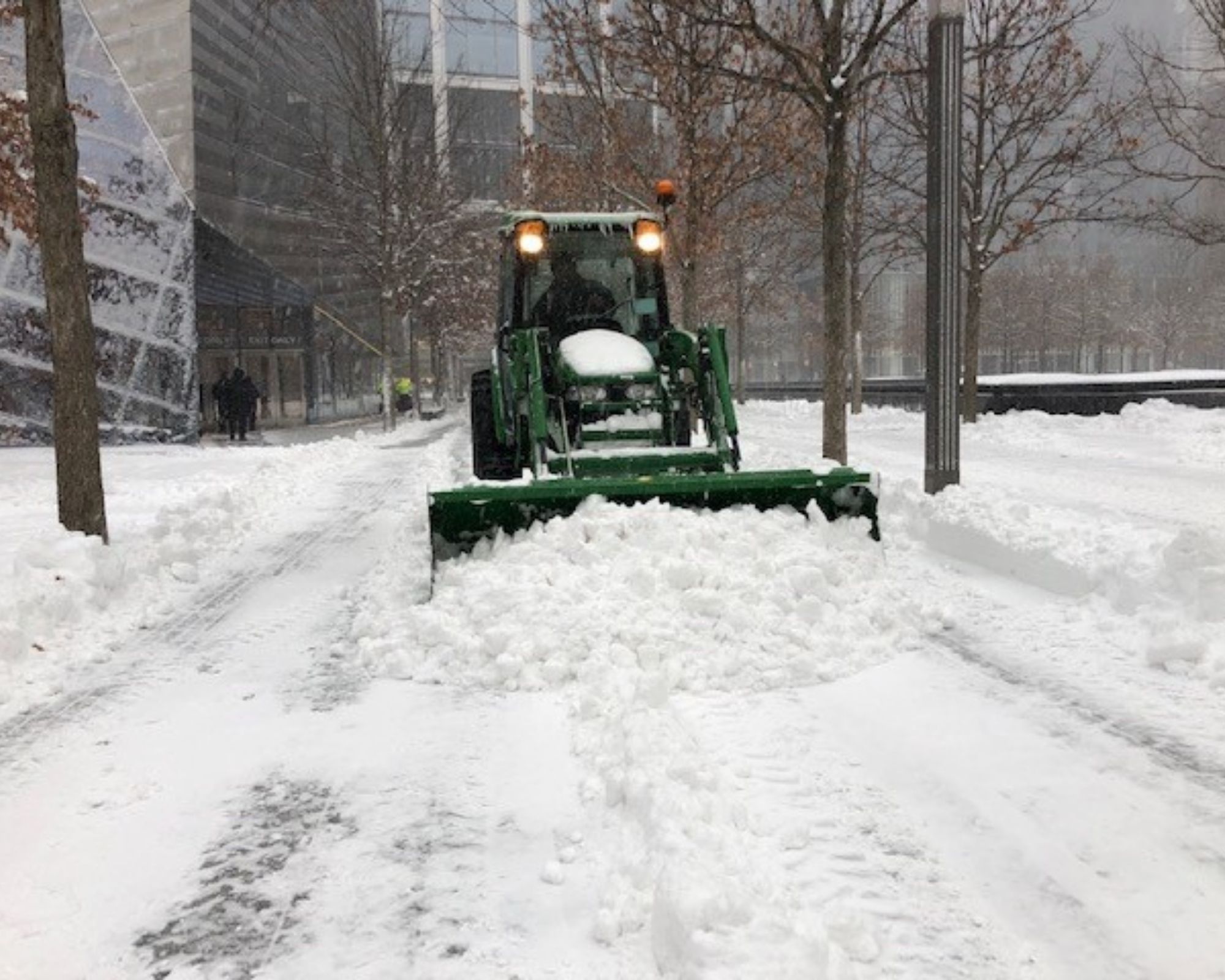 A dark green plough clears snow on the Memorial