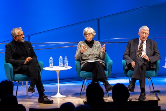 three panelists engage in conversation on stage