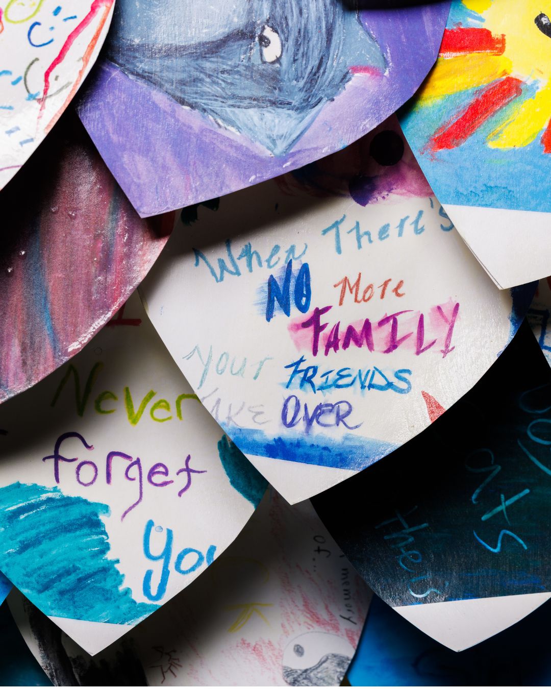 Paper feathers adorned with messaging and artwork made by children