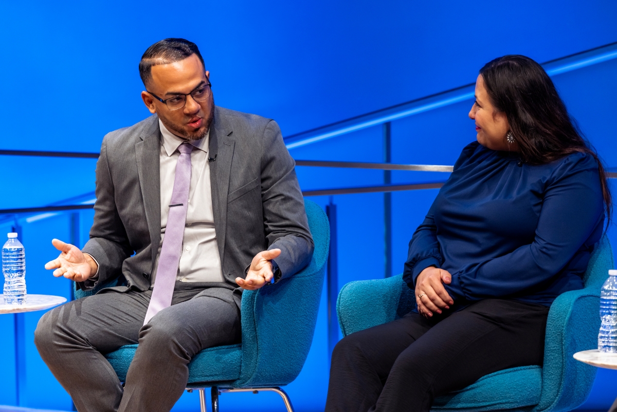 a man and woman speak on stage