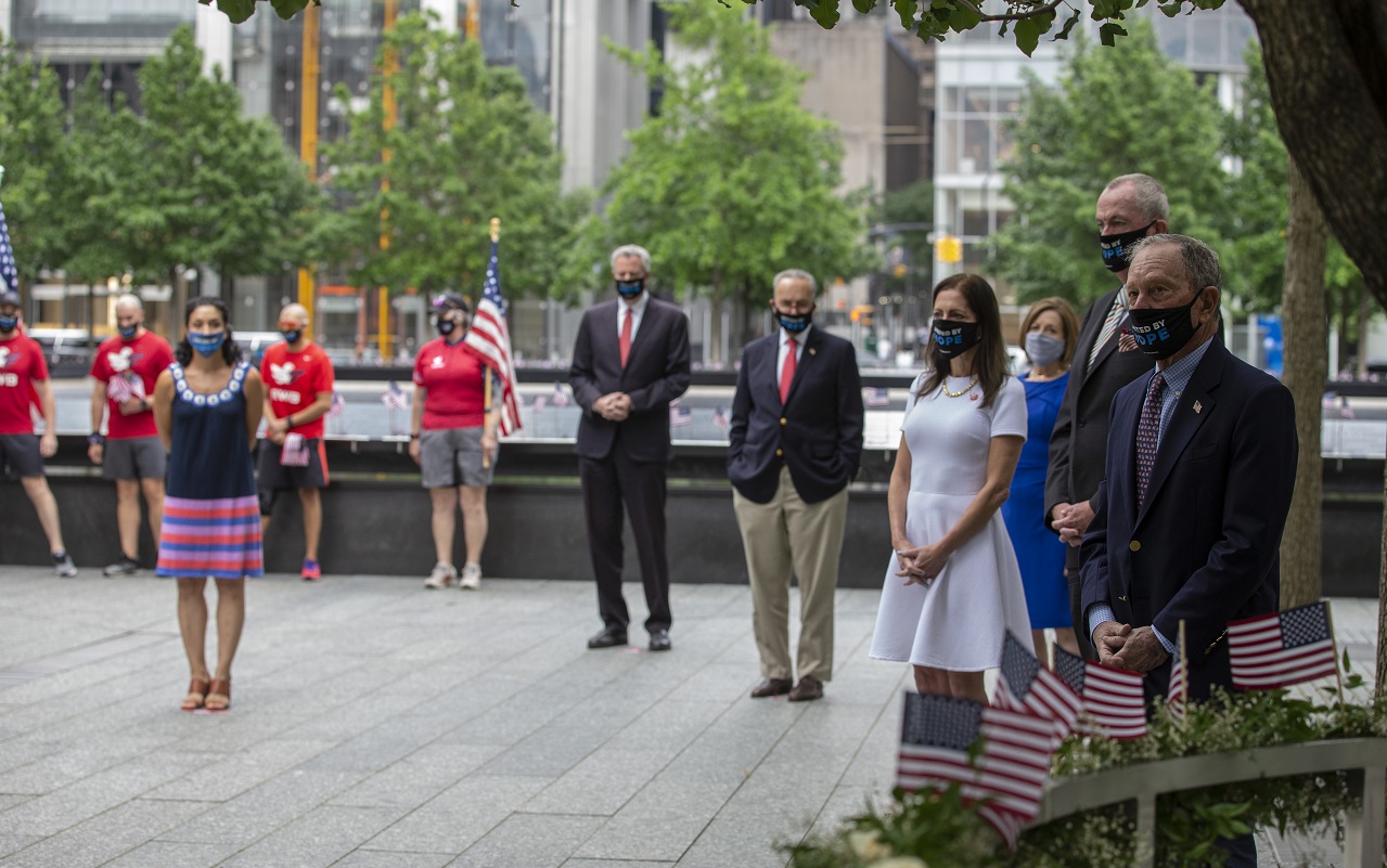 Dignitaries stand socially distanced and wearing face masks during a small ceremony on the 9/11 Memorial plaza. 