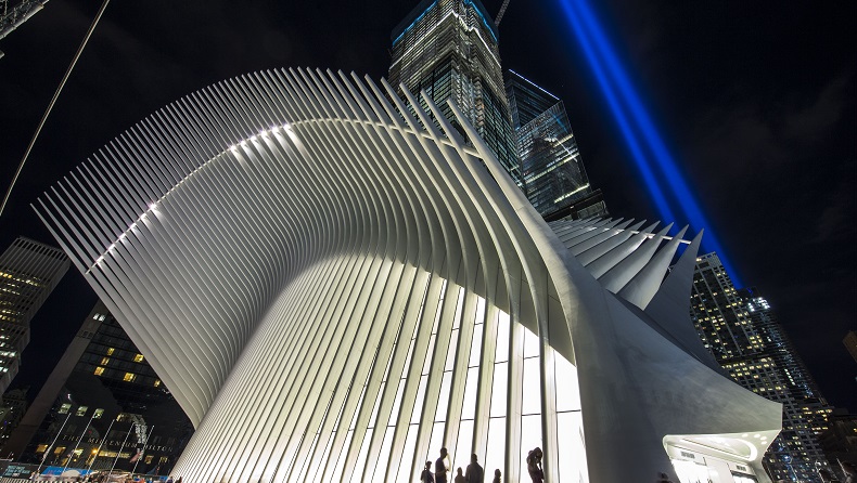 The annual Tribute in Light shines behind the Oculus at night. 