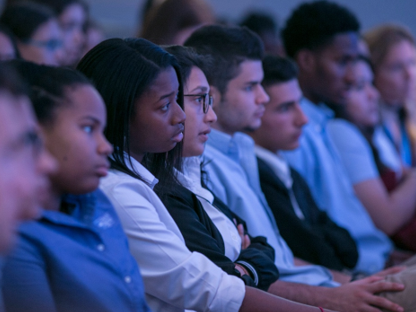 A row of students listening to a speaker 