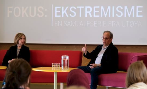 A woman (left) and a man (right) speak on a panel 