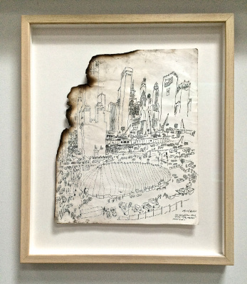 Framed drawing of altered lower Manhattan skyline, with upper left corner singed and missing a piece