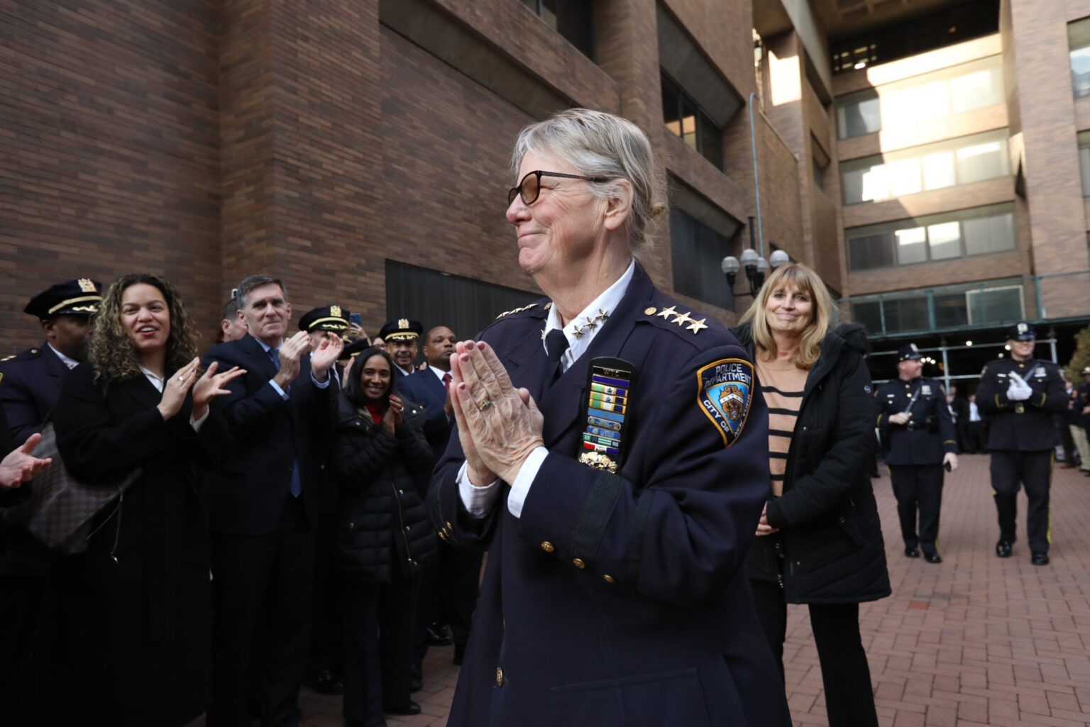 Chief Tobin claps, surrounded by officers