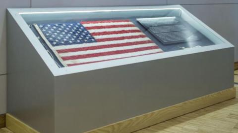 An American flag displayed in a glass case
