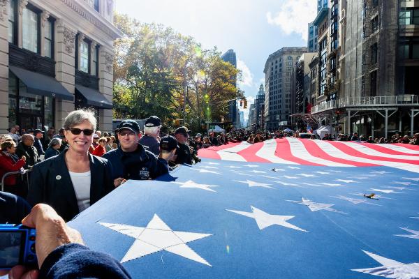 President & CEO Beth Hillman joins Memorial staff and volunteers to carry a massive flag along Fifth Avenue in the NYC Veterans Day Parade. 