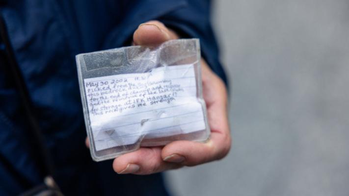 Close-up of a hand holding a hand-written note covered in clear plastic