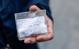 Close-up of a hand holding a hand-written note covered in clear plastic