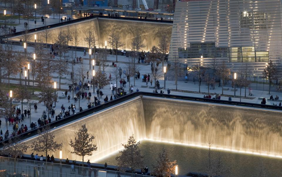 Visitors walk around the 9/11 Memorial's two massive reflecting pools set within the original footprints of the twin towers. (AP photo/Mark Lennihan) APMarkLennihanMemorial.jpg