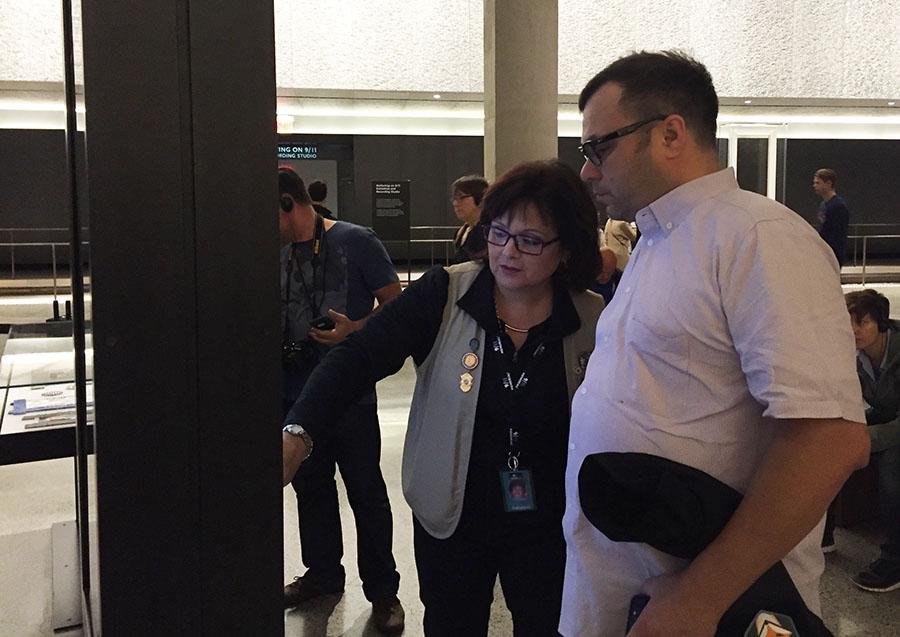 Sonia Agron, a 9/11 Memorial Museum docent, shows a visitor the virtual interactive for the Last Column in Foundation Hall.