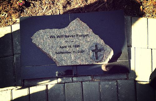 A plaque commemorating the 1995 terror bombing in Oklahoma City and the 2001 attacks in New York City is seen rising out of a brick walkway.