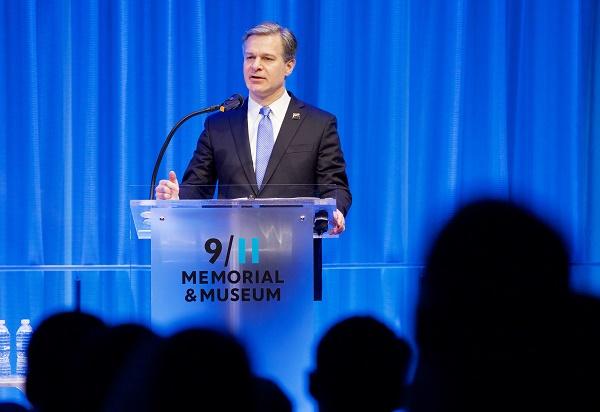 FBI Director Christopher Wray speaks at a lectern in the Museum auditorium.