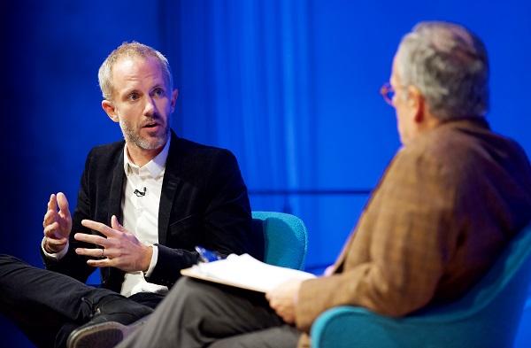 Sociologist Gérôme Truc gestures as he speaks onstage during a public program at the Museum auditorium.