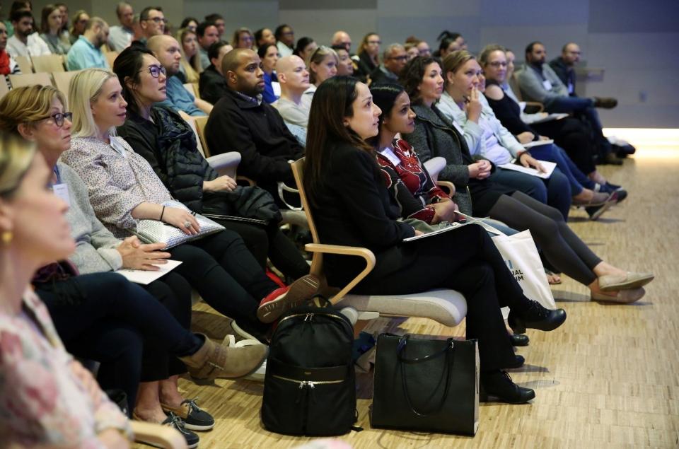 An audience of dozens of teachers sit and listen to a keynote presentation at the Museum’s auditorium.