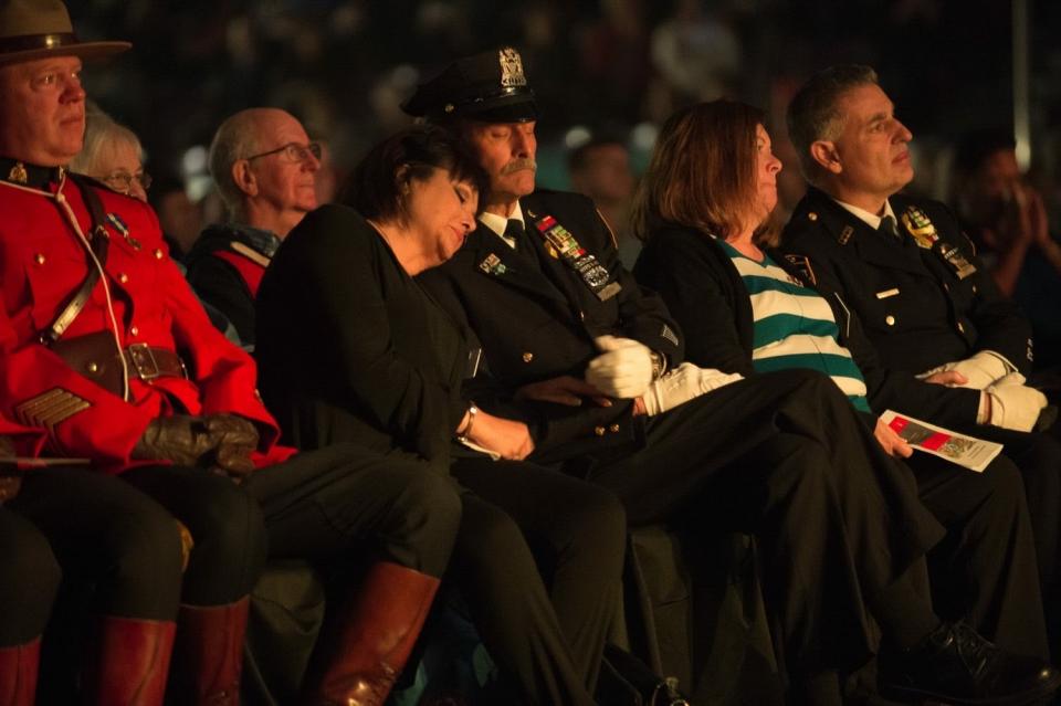 Sonia and Joe Agron embrace while seated at an event. Joe is in a formal NYPD uniform.
