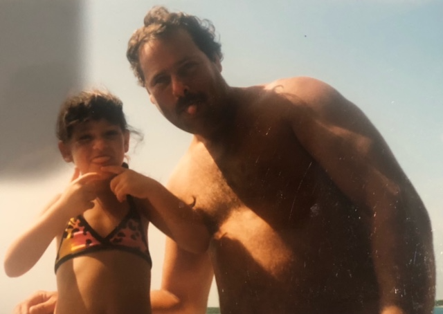 A female child and her father make funny faces at the camera.